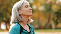 Vrouw geniet in de herfstzon 