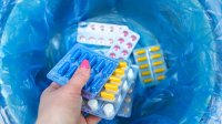 Vrouw gooit medicijnen in prullenbak