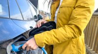 Vrouw laadt elektrische auto op