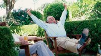 Man in zijn achtertuin juichend omdat hij met pensioen is