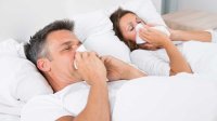 Man en vrouw liggen samen in bed met griep