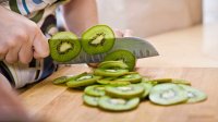 Vrouw snijdt kiwi's
