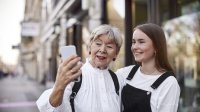 Oudere en jongere vrouwen nemen samen selfie