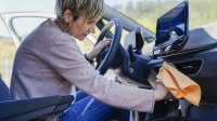 oudere vrouw maakt auto van binnen schoon
