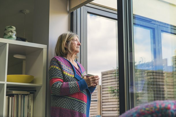 Gas en stroom besparen oudere vrouw kijkt uit het raam
