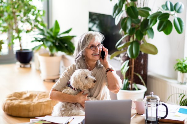 Vrouw met hond voert een vrolijke telefoongesprek