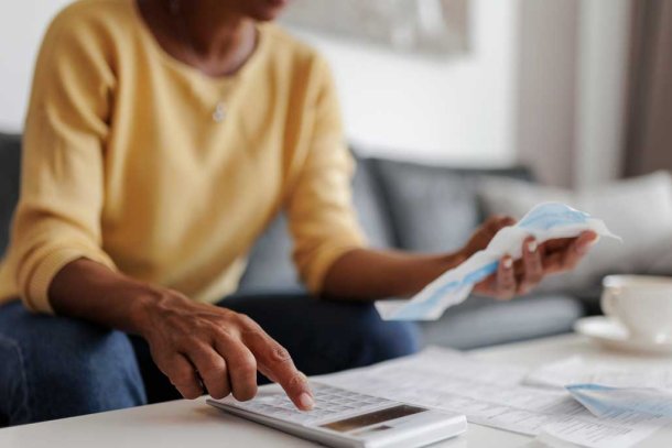 Vrouw met rekeningen en rekenmachine 