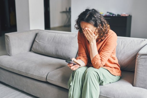 vrouw kijkt somber naar haar telefoon