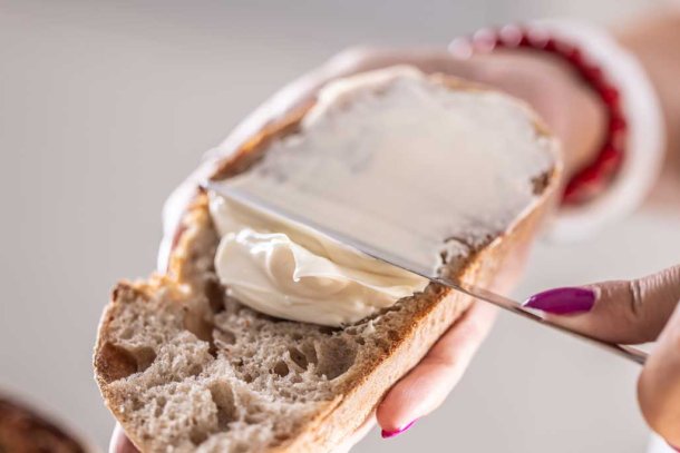 vrouw smeert margarine op brood
