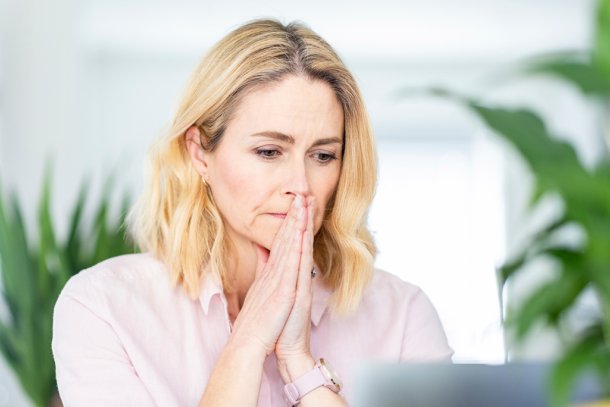 Vrouw bezorgd achter computer, zal ik inloggen of niet?