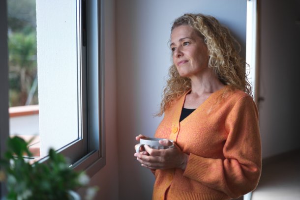 Vrouw drinkt koffie in haar slaapkamer
