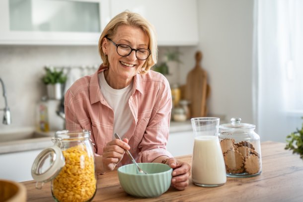 Vrolijke vrouw eet havermout in de keuken