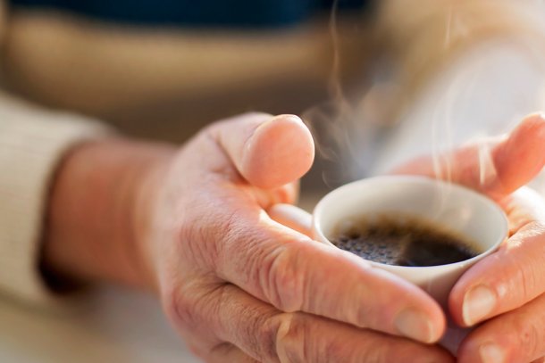 Vrouw warmt handen aan koffie