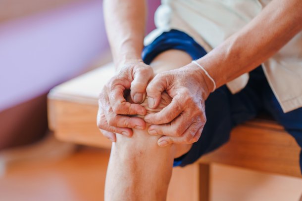 man voelt aan knie