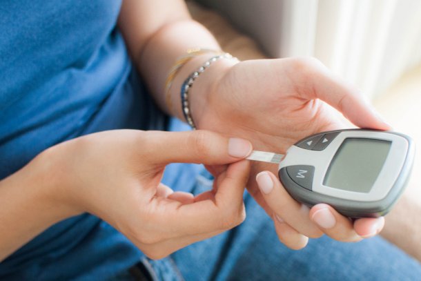 Vrouw meet thuis met glucosemeter