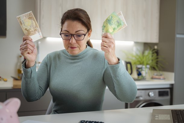 Vrouw met bankbiljetten in de hand controleert status van haar hypotheek