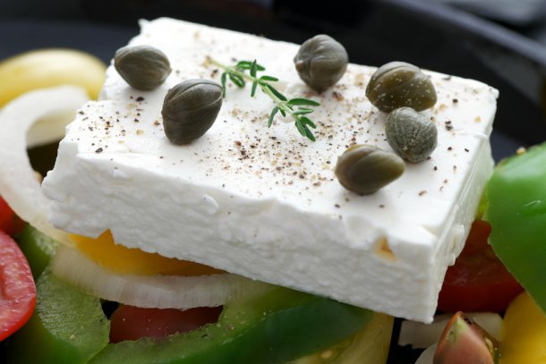 Stuk feta op een Griekse salade met olijven