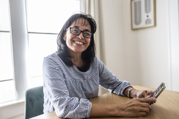 Dame met smartphone in de hand, grijnzend