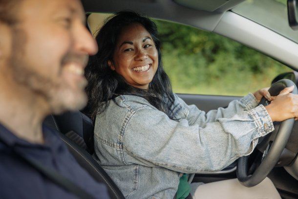 Vrouw achter het stuur met man ernaast in de auto