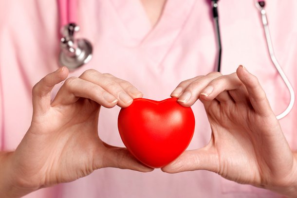 Arts met stethoscoop om de nek en in haar hand een hart