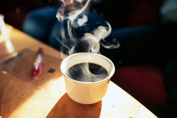 Een kop koffie op tafel in de zon