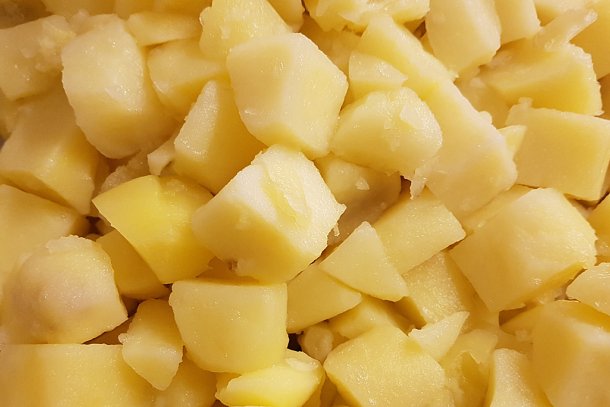 Afgekoelde gekookte aardappelen in partjes gesneden