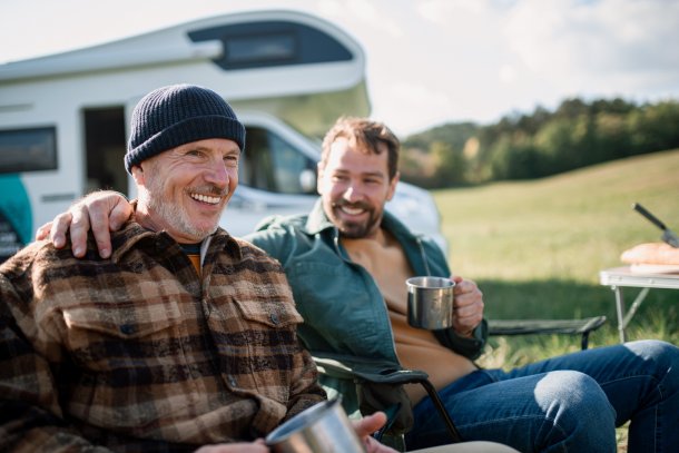 Vader en zoon zitten voor een camper