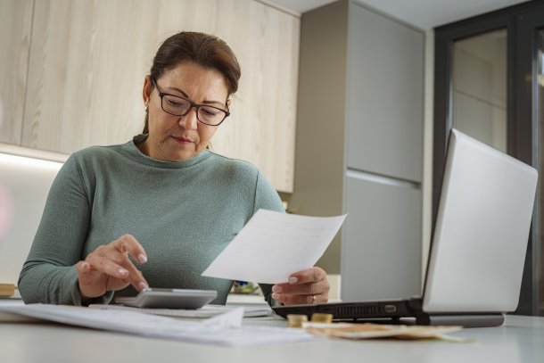 Vrouw is thuis bezig met berekeningen