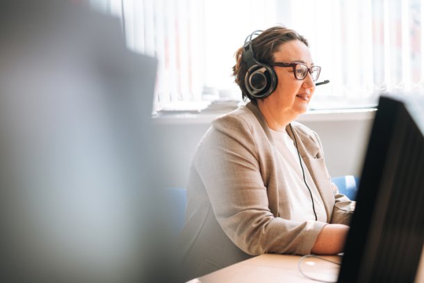 Medewerker klantenservice zit aan de telefoon