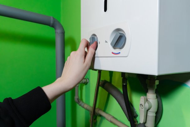 CV ketel met vrouwenhand aan de knop