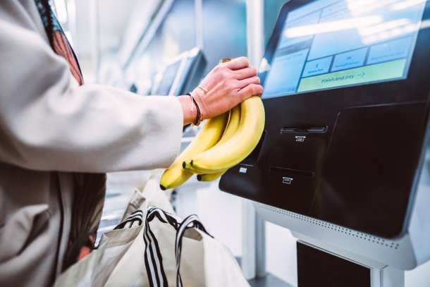 Vrouw rekent bananen af bij de zelfscankassa