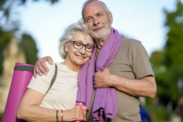 Man en vrouw doen samen aan hardlopen, poseren met handdoek