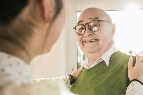 Oudere man in gesprek met jongere verzorgster