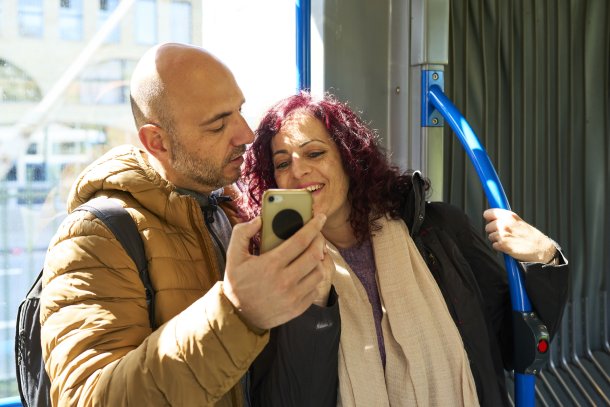 Man en vrouw bekijken telefoon in de bus