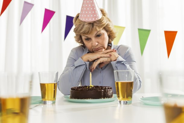 Vrouw viert verjaardag alleen met chocoladetaart, sip gezicht