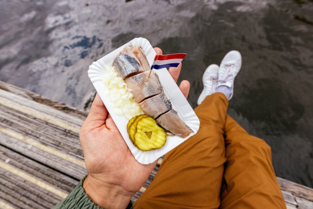 Man eet haring met uitjes en zuur