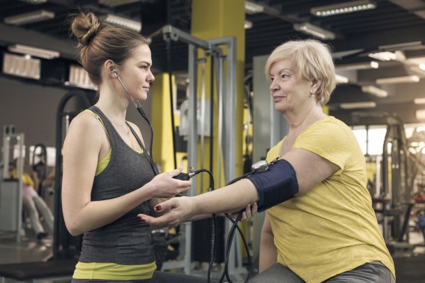 vrouw meet bloeddruk in sportschool