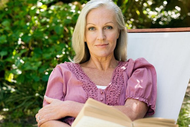 Vrouw leest boek in de tuin