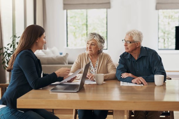 Makelaar in gesprek met senior stel aan de keukentafel