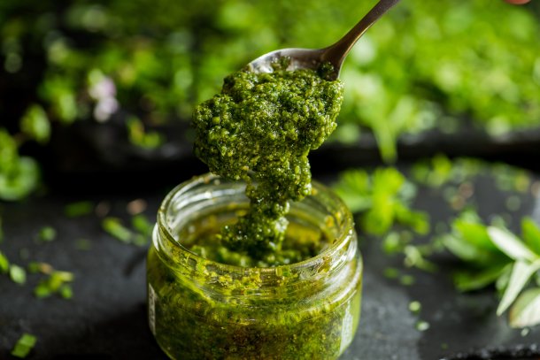 potje groene pesto met een lepel erin