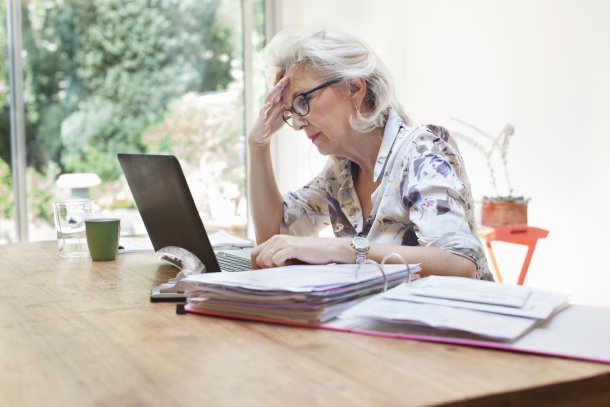 Vrouw achter laptop met zorgelijke blik