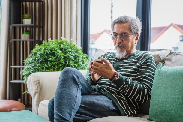 Man zit op de bank zijn zaken door te nemen op smartphone