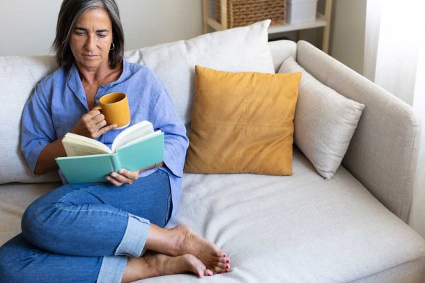 Vrouw zit op de bank te lezen