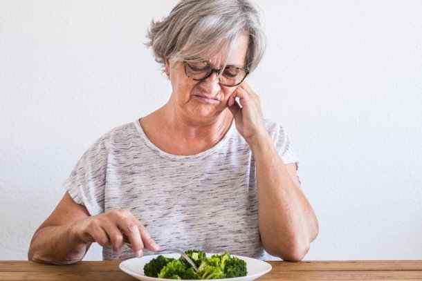 vrouw kijkt vies naar haar bord met eten