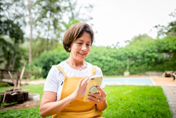 Vrouw met smartphone in de tuin