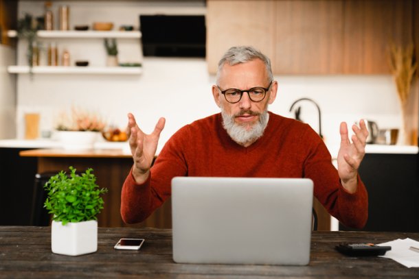 Man zit vertwijfeld achter laptop