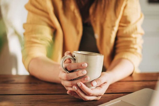 Vrouw drinkt koffie achter  laptop
