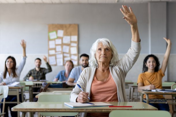 Oudere vrouw steekt hand op