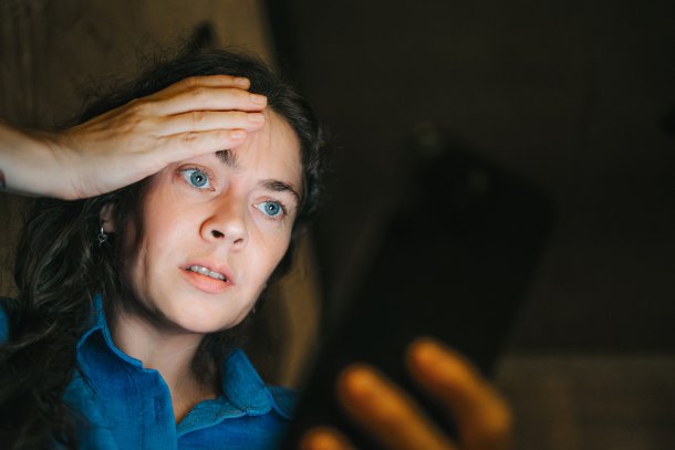 Vrouw kijkt verschikt op haar telefoon