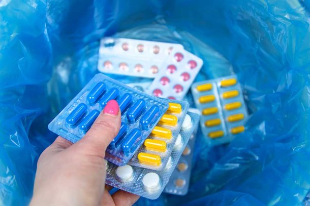 Vrouw gooit medicijnen in prullenbak